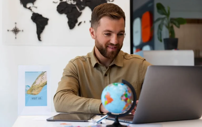 Founder researching hiring global talent while looking at globe and laptop in modern office