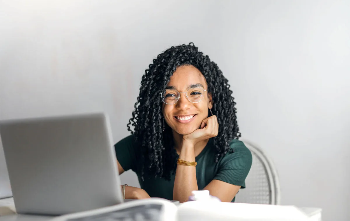 Smiling remote executive assistant working on a laptop at home.
