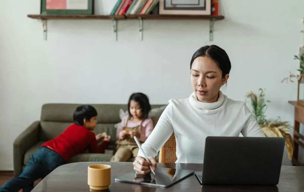 Remote executive assistant working from home while children play in background
