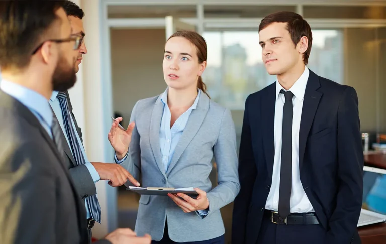 Business professionals discussing project strategy with a tablet while evaluating offshore development companies partnership options.